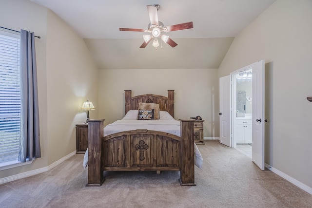 bedroom with light colored carpet, vaulted ceiling, ensuite bath, and baseboards