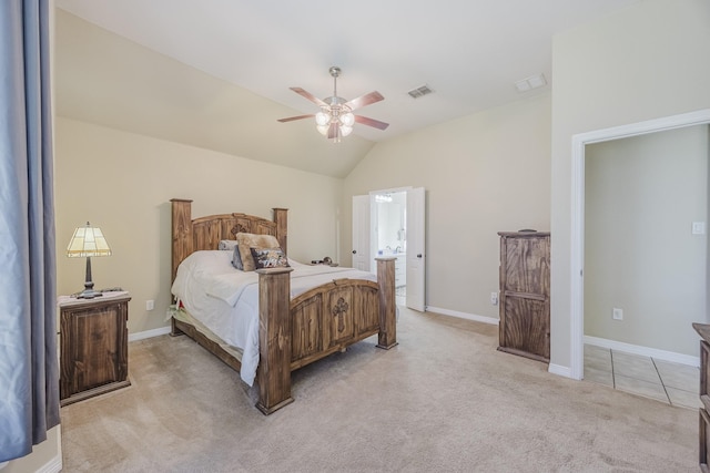 bedroom featuring light colored carpet, vaulted ceiling, a ceiling fan, ensuite bath, and baseboards
