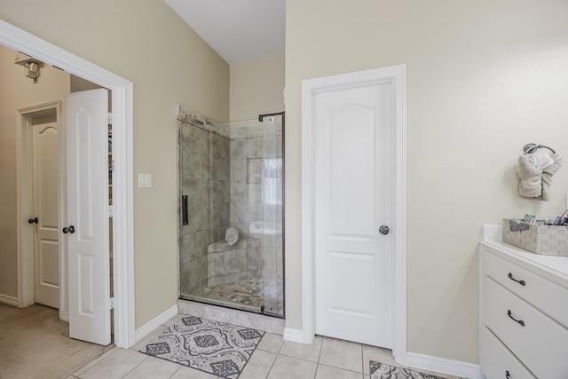 full bathroom with a shower stall, baseboards, tile patterned flooring, and vanity
