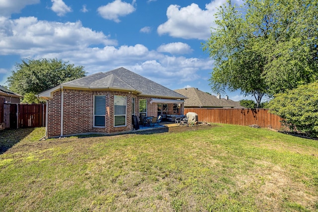 back of property with a patio area, brick siding, and roof with shingles