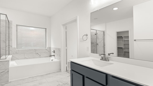 1906 Bobbin Ml, Forney, TX 75126 - full bathroom featuring a garden tub, vanity, marble look tile flooring, a walk in closet, and a shower