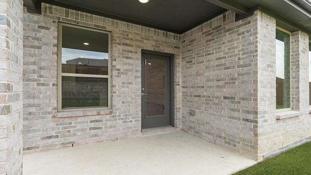 1906 Bobbin Ml, Forney, TX 75126 - view of exterior entry with brick siding and a patio