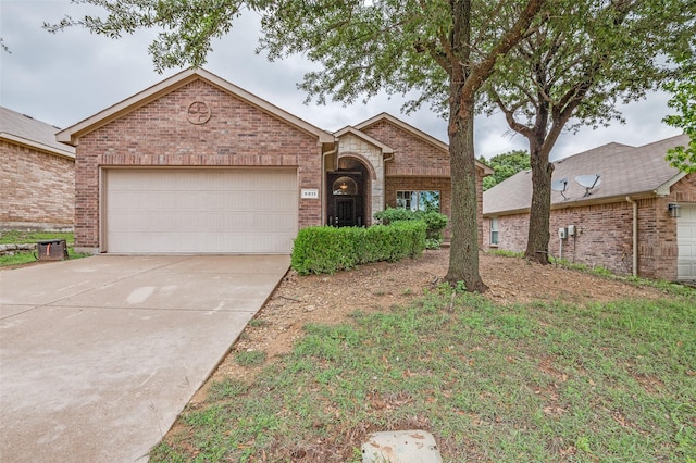 view of front of home featuring concrete driveway, brick siding, and a garage