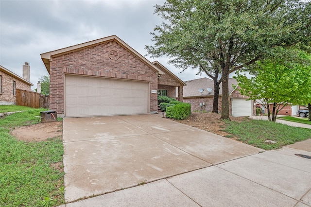 view of front facade featuring brick siding, fence, and driveway