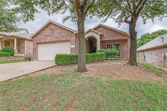 view of front of home featuring a garage, driveway, and brick siding