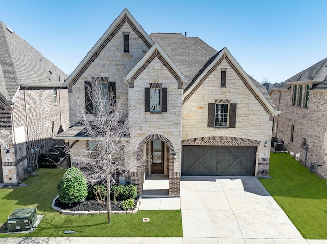 720 Waterbrook Pkwy, Argyle, TX 76226 - french country inspired facade featuring stone siding, a garage, driveway, cooling unit, and a front yard