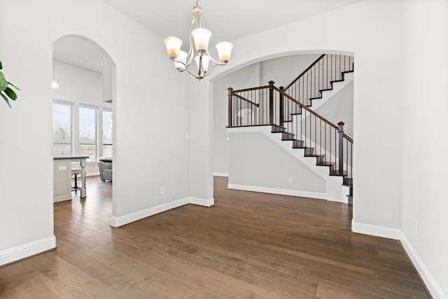 720 Waterbrook Pkwy, Argyle, TX 76226 - unfurnished dining area featuring hardwood / wood-style floors, a chandelier, stairs, and arched walkways