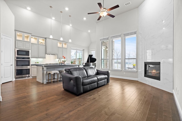 720 Waterbrook Pkwy, Argyle, TX 76226 - living room with high vaulted ceiling, dark wood-style flooring, a ceiling fan, recessed lighting, and baseboards