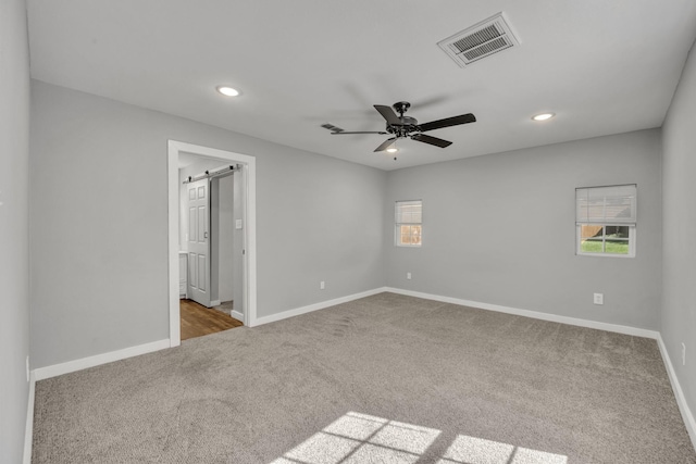 1213 E Laurel St, Tyler, TX 75702 - unfurnished bedroom featuring carpet flooring, recessed lighting, baseboards, a barn door, and a ceiling fan