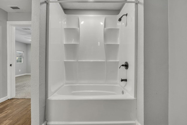 1213 E Laurel St, Tyler, TX 75702 - full bathroom with wood finished floors, shower / tub combination, and baseboards
