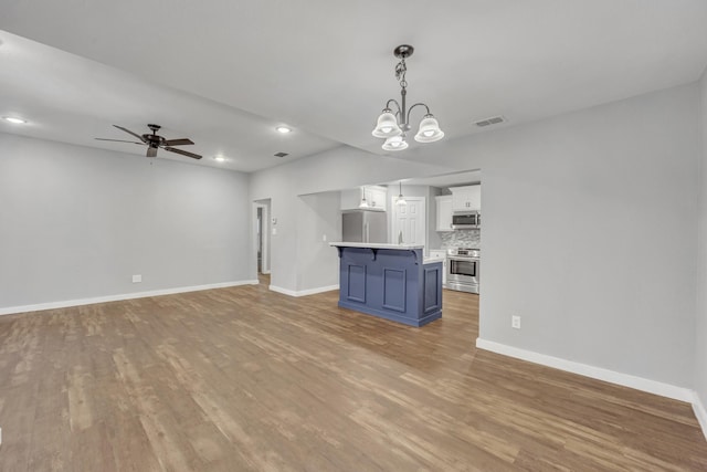 1213 E Laurel St, Tyler, TX 75702 - unfurnished living room featuring wood finished floors, baseboards, ceiling fan, recessed lighting, and a chandelier