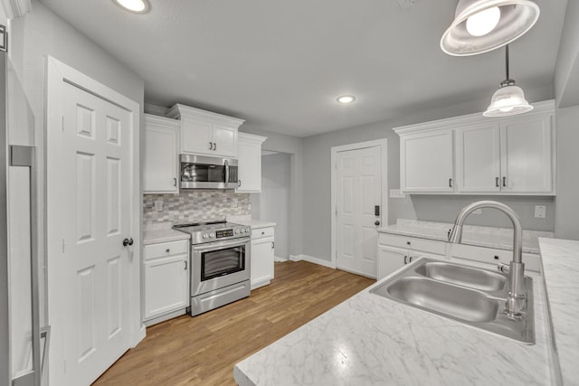 1213 E Laurel St, Tyler, TX 75702 - kitchen featuring appliances with stainless steel finishes, a sink, recessed lighting, light countertops, and white cabinets