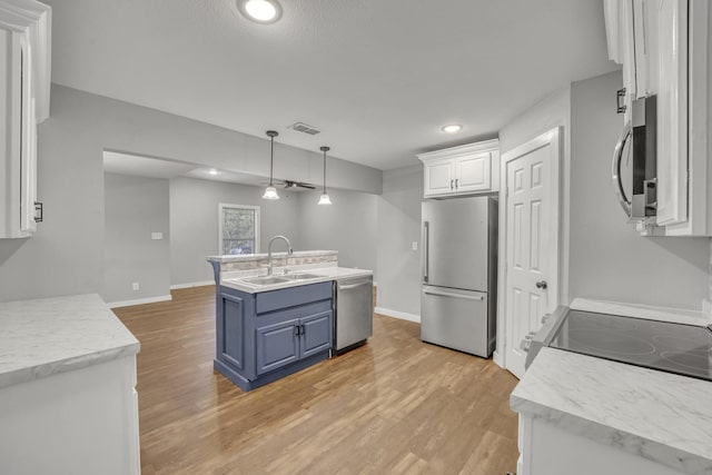 1213 E Laurel St, Tyler, TX 75702 - kitchen with appliances with stainless steel finishes, a sink, blue cabinetry, white cabinetry, and light wood-style floors