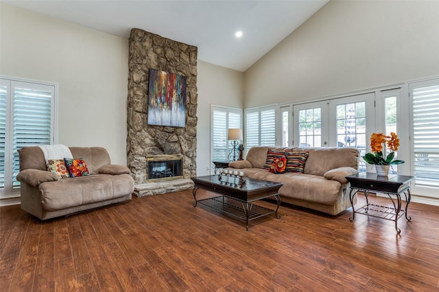 living area featuring high vaulted ceiling, wood finished floors, and a fireplace
