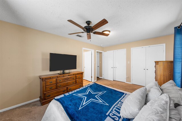 163 Private Road 605, Marlin, TX 76661 - bedroom with multiple closets, light carpet, baseboards, a textured ceiling, and a ceiling fan