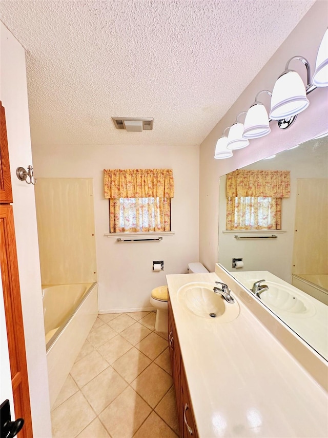 408 Briarwood Dr, Eastland, TX 76448 - bathroom with a bathtub, tile patterned floors, a textured ceiling, vanity, and toilet