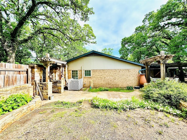 408 Briarwood Dr, Eastland, TX 76448 - back of house featuring a pergola, brick siding, a patio area, and fence