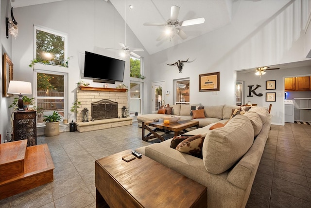 2608 Rivercrest Dr, Arlington, TX 76006 - living area with high vaulted ceiling, washer / clothes dryer, a ceiling fan, a stone fireplace, and tile patterned floors