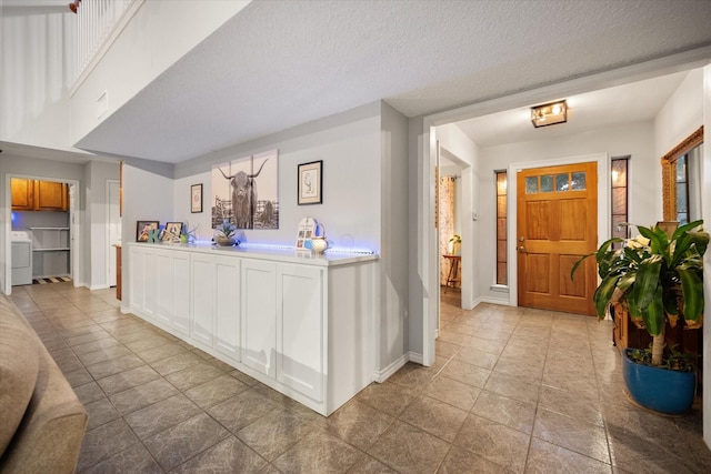 2608 Rivercrest Dr, Arlington, TX 76006 - foyer with washer / dryer, light tile patterned flooring, and baseboards