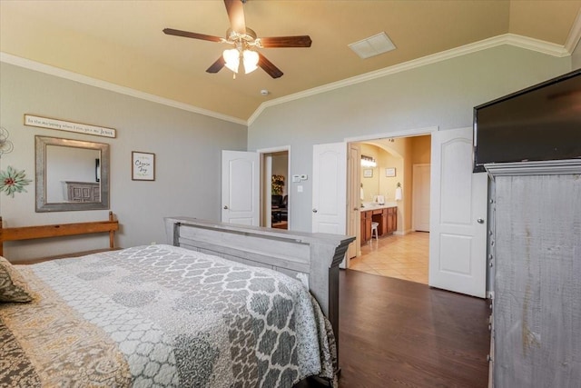 bedroom with lofted ceiling, dark wood-style flooring, ornamental molding, arched walkways, and a ceiling fan