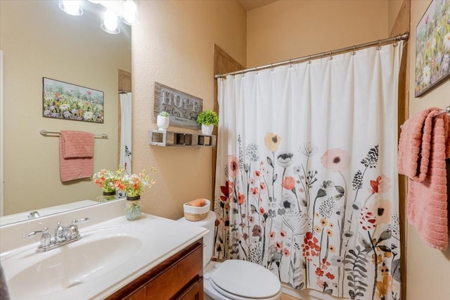 full bathroom with toilet, vanity, a textured wall, and a shower with curtain