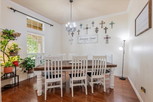dining space with a chandelier, crown molding, wood finished floors, and baseboards