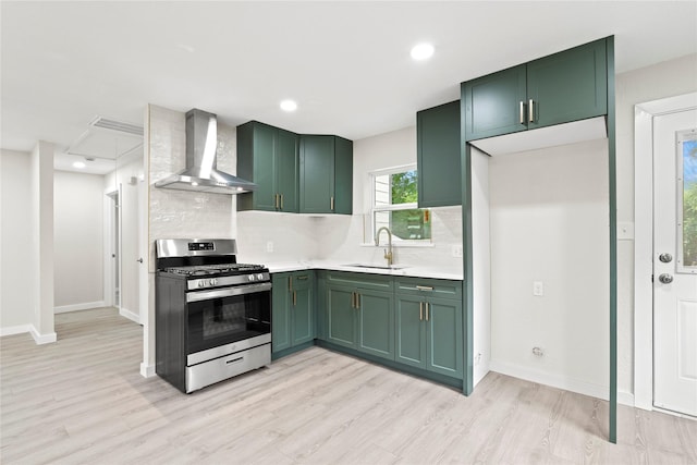5101 Penrod Ct, River Oaks, TX 76114 - kitchen featuring green cabinetry, stainless steel range with gas stovetop, wall chimney range hood, a sink, and tasteful backsplash