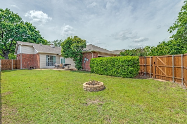 view of yard with a fire pit, a patio area, and a gate