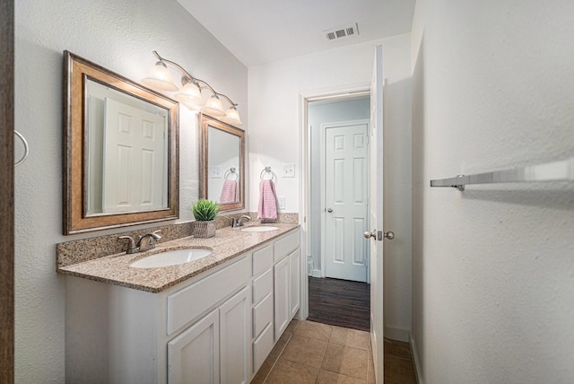 bathroom with tile patterned flooring, double vanity, and baseboards