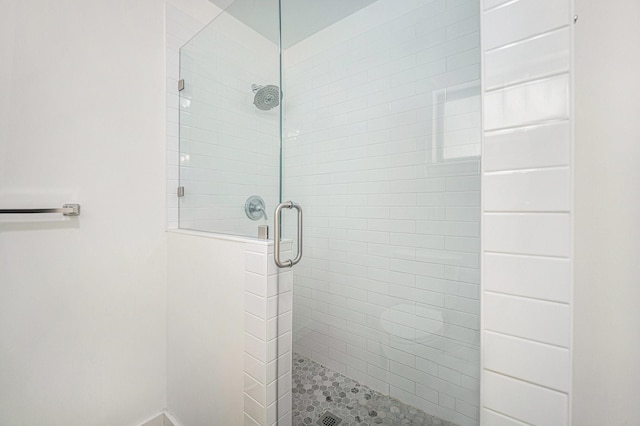 full bathroom featuring a shower stall and baseboards