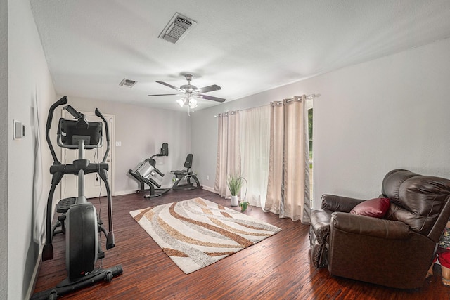 workout room with wood finished floors, a ceiling fan, and baseboards