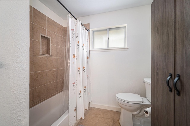 bathroom featuring toilet, tile patterned floors, shower / bath combo, and baseboards