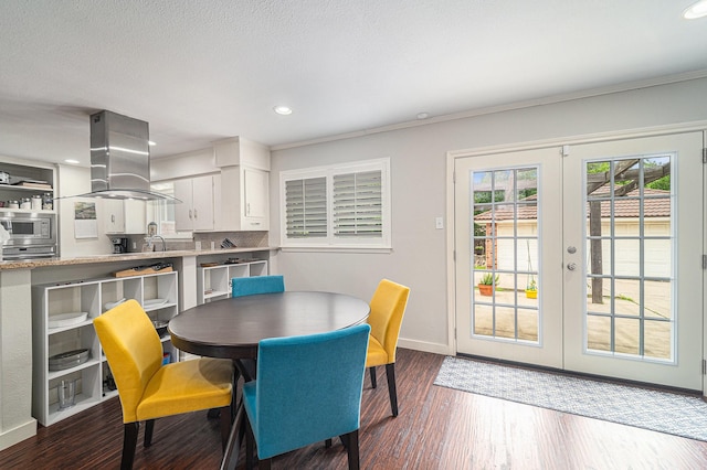 dining space with baseboards, wood finished floors, french doors, and recessed lighting