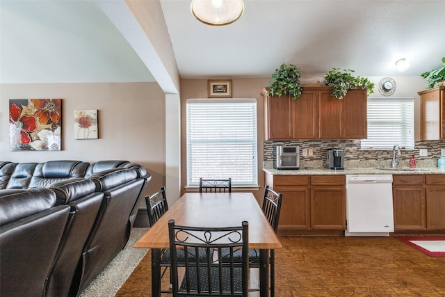4012 Summerhill Ln, Fort Worth, TX 76244 - kitchen with white dishwasher, a sink, open floor plan, backsplash, and brown cabinetry