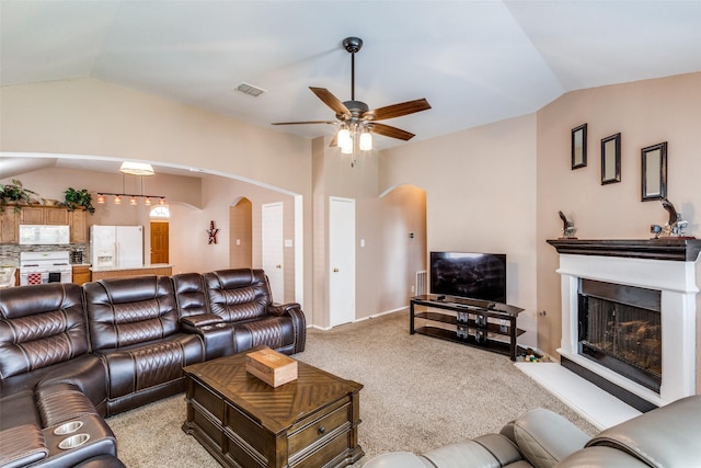 4012 Summerhill Ln, Fort Worth, TX 76244 - living room featuring lofted ceiling, arched walkways, ceiling fan, light carpet, and a fireplace with raised hearth