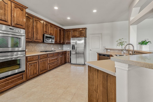 1837 Trail Dr, Rockwall, TX 75087 - kitchen with appliances with stainless steel finishes, a sink, recessed lighting, light countertops, and tasteful backsplash