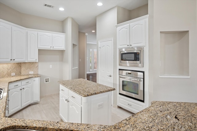 11968 Cobblestone Dr, Frisco, TX 75035 - kitchen with stainless steel appliances, light stone countertops, white cabinetry, and recessed lighting