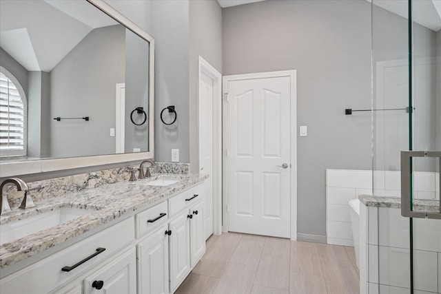 11968 Cobblestone Dr, Frisco, TX 75035 - bathroom featuring double vanity and vaulted ceiling