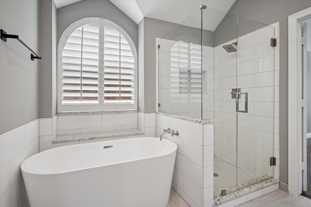 11968 Cobblestone Dr, Frisco, TX 75035 - full bathroom with a shower stall, a freestanding tub, tile walls, and lofted ceiling