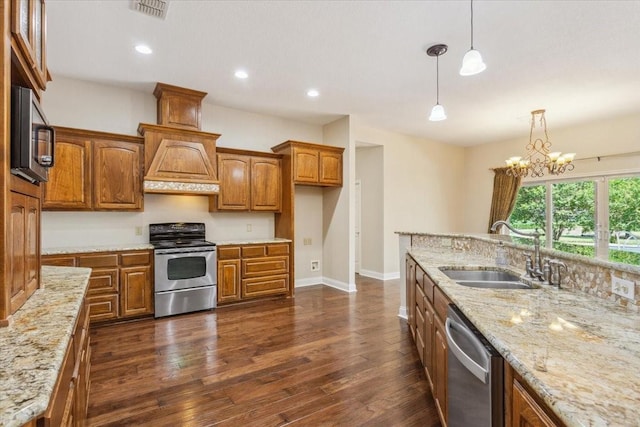 3439 Willow Branch Rd, Mcgregor, TX 76657 - kitchen with stainless steel appliances, a sink, brown cabinetry, light stone counters, and recessed lighting
