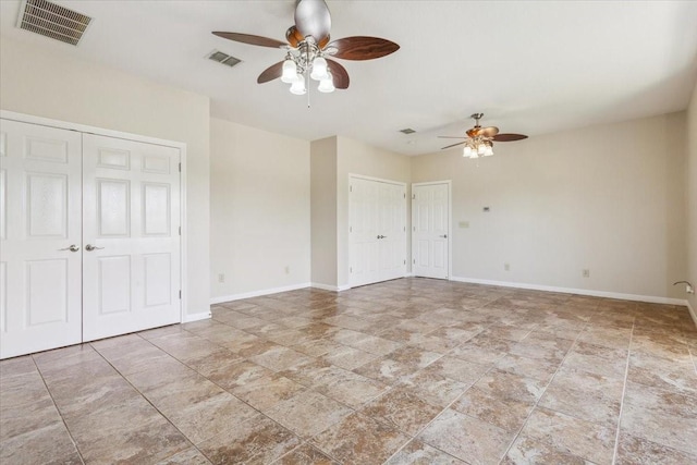 3439 Willow Branch Rd, Mcgregor, TX 76657 - unfurnished bedroom featuring multiple closets, stone finish flooring, baseboards, and a ceiling fan