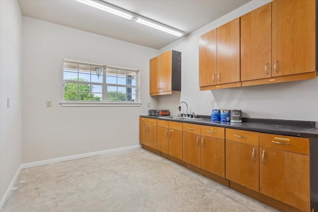 3439 Willow Branch Rd, Mcgregor, TX 76657 - kitchen featuring a sink, dark countertops, brown cabinets, and baseboards