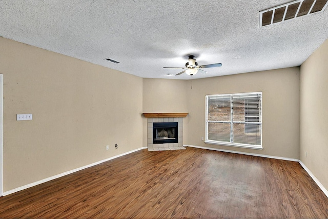1523 Allen Dr, Cedar Hill, TX 75104 - unfurnished living room with ceiling fan, wood finished floors, a tile fireplace, baseboards, and a textured ceiling