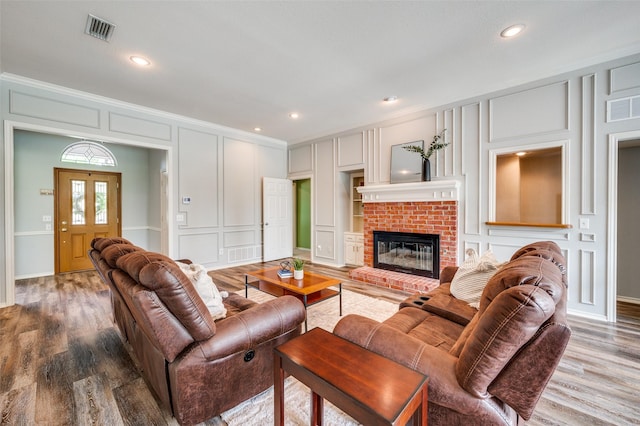 3336 Sage Brush Trl, Plano, TX 75023 - living room featuring a decorative wall, crown molding, wood finished floors, recessed lighting, and a fireplace