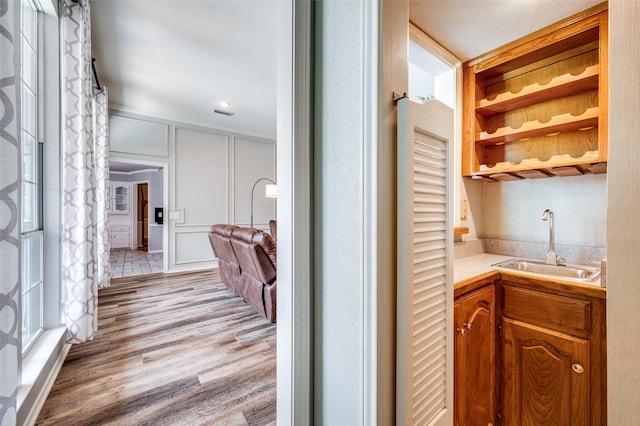 3336 Sage Brush Trl, Plano, TX 75023 - hall featuring a sink, light wood-style floors, and a decorative wall