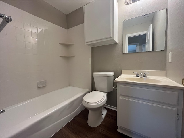 full bathroom featuring wood finished floors, toilet, baseboards, vanity, and tub / shower combination