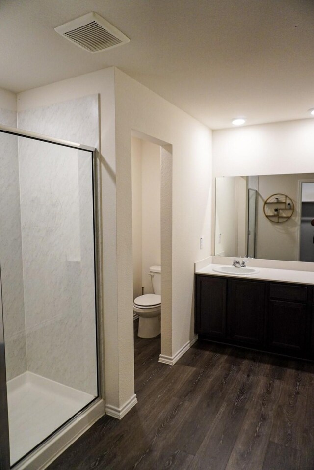 3128 Bettin Dr, Mesquite, TX 75126 - bathroom featuring wood finished floors, toilet, a stall shower, vanity, and baseboards