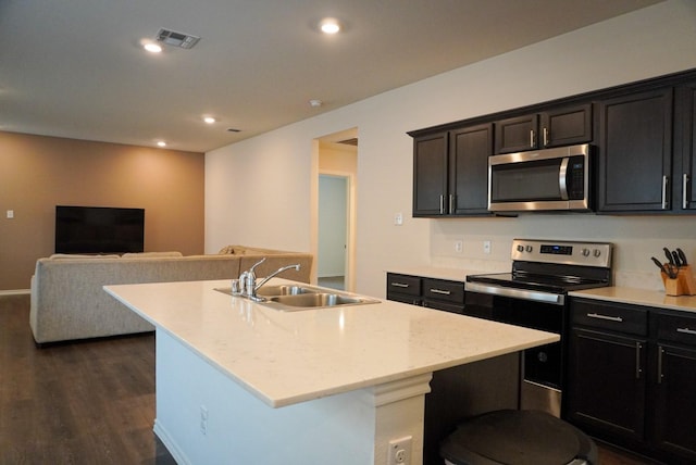 3128 Bettin Dr, Mesquite, TX 75126 - kitchen featuring stainless steel appliances, a sink, dark wood-style floors, a kitchen island with sink, and open floor plan