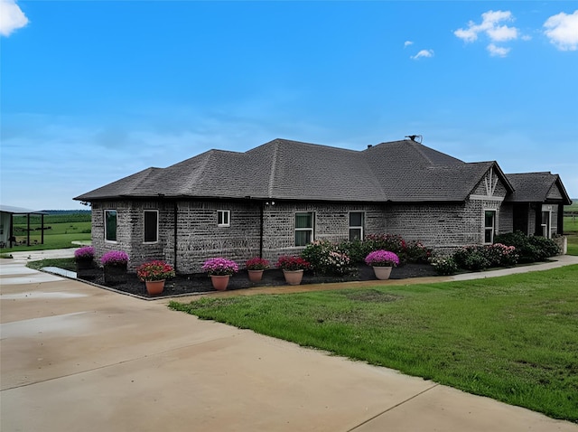 1061 N Whitt Rd, Perrin, TX 76486 - view of home's exterior with a yard, brick siding, and roof with shingles