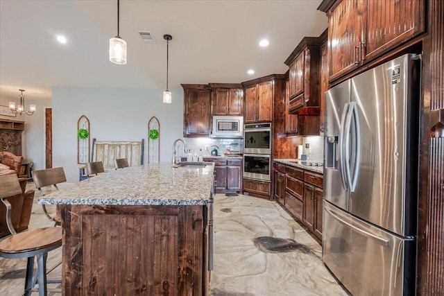 1061 N Whitt Rd, Perrin, TX 76486 - kitchen with stainless steel appliances, a sink, a breakfast bar area, tasteful backsplash, and recessed lighting